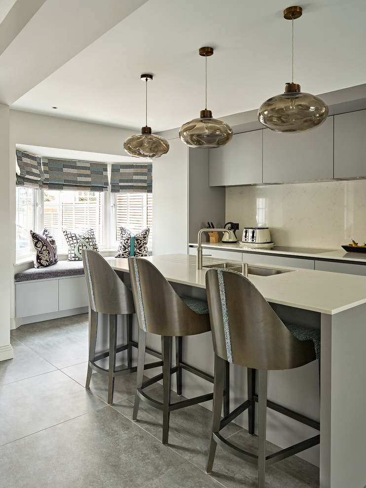 Photo of a mid-sized contemporary kitchen in London with flat-panel cabinets, grey cabinets, with island, a double-bowl sink, beige splashback, grey floor and beige benchtop.
