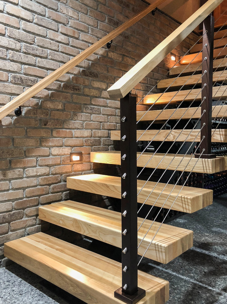 Inspiration for a mid-sized industrial wood straight staircase in Denver with open risers and cable railing.
