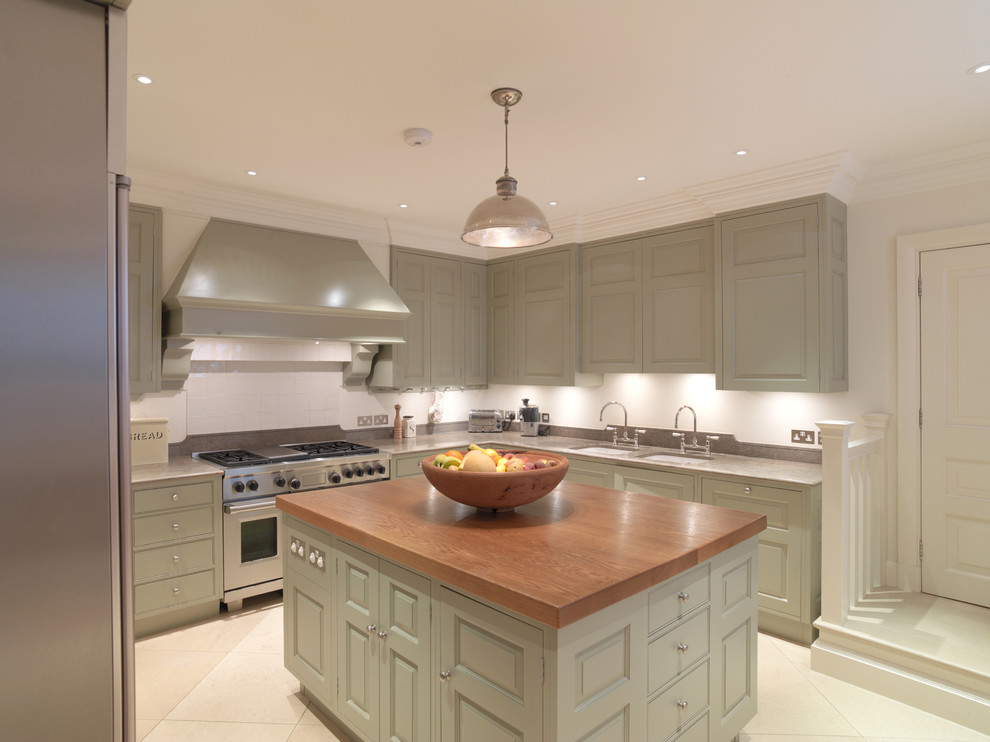 Photo of a large contemporary eat-in kitchen in Other with an undermount sink, raised-panel cabinets, green cabinets, limestone benchtops, white splashback, stainless steel appliances, limestone floors and with island.