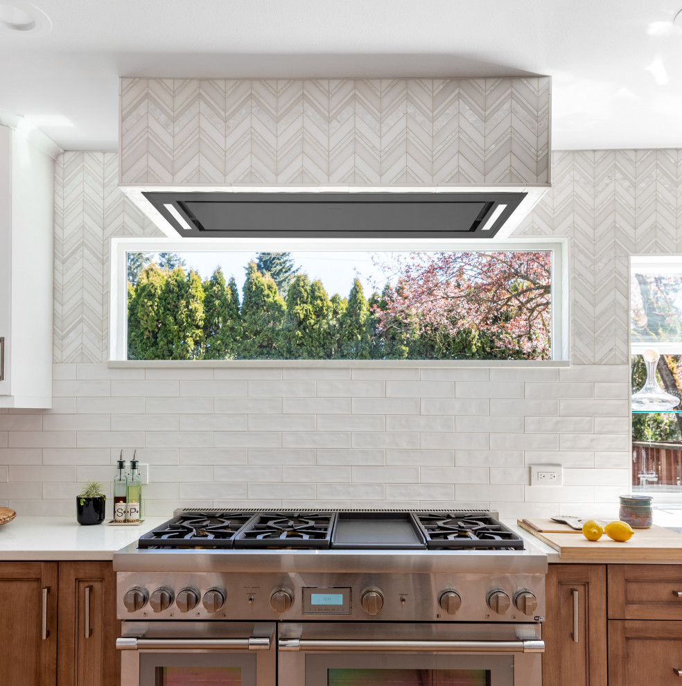 Example of a large transitional light wood floor and brown floor kitchen design in Seattle with a farmhouse sink, medium tone wood cabinets, quartz countertops, white backsplash, mosaic tile backsplash, stainless steel appliances, an island and white countertops