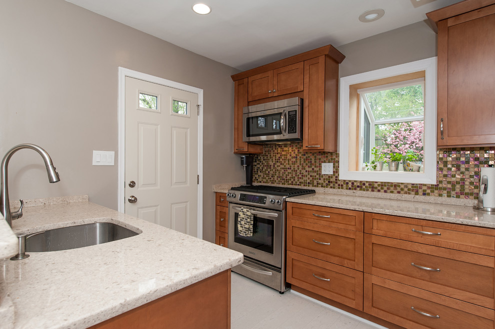 Example of a large transitional galley cork floor eat-in kitchen design in DC Metro with an undermount sink, shaker cabinets, brown cabinets, quartz countertops, multicolored backsplash, glass tile backsplash and stainless steel appliances