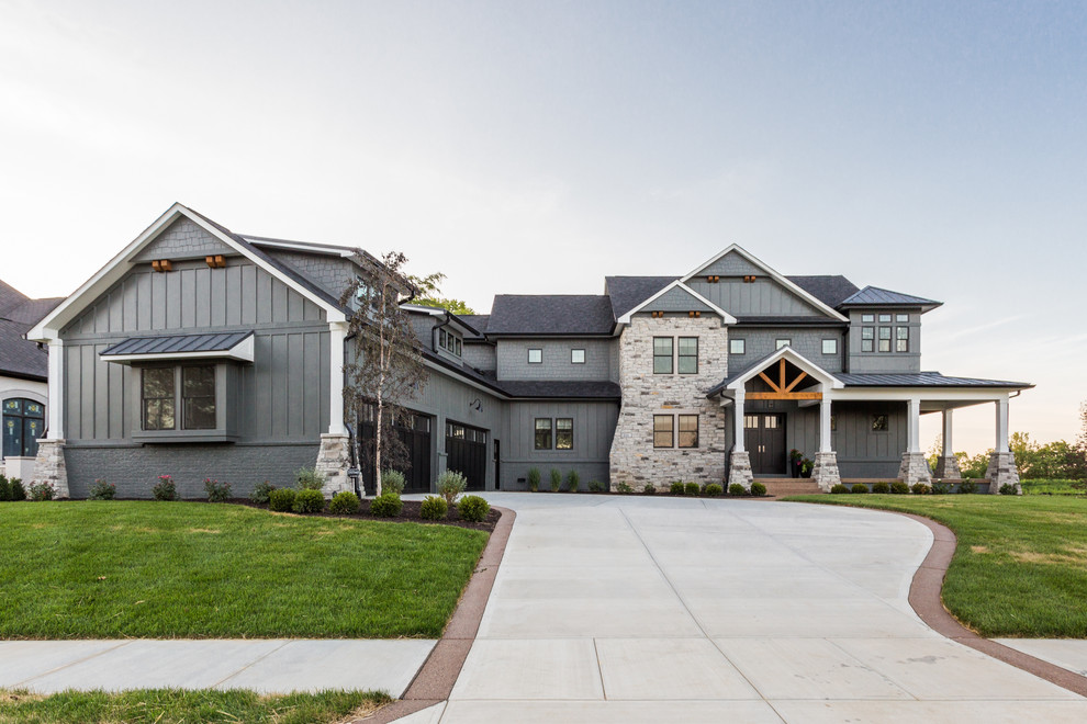 Photo of a large transitional two-storey grey house exterior in Indianapolis with mixed siding, a gable roof, a shingle roof, board and batten siding and shingle siding.