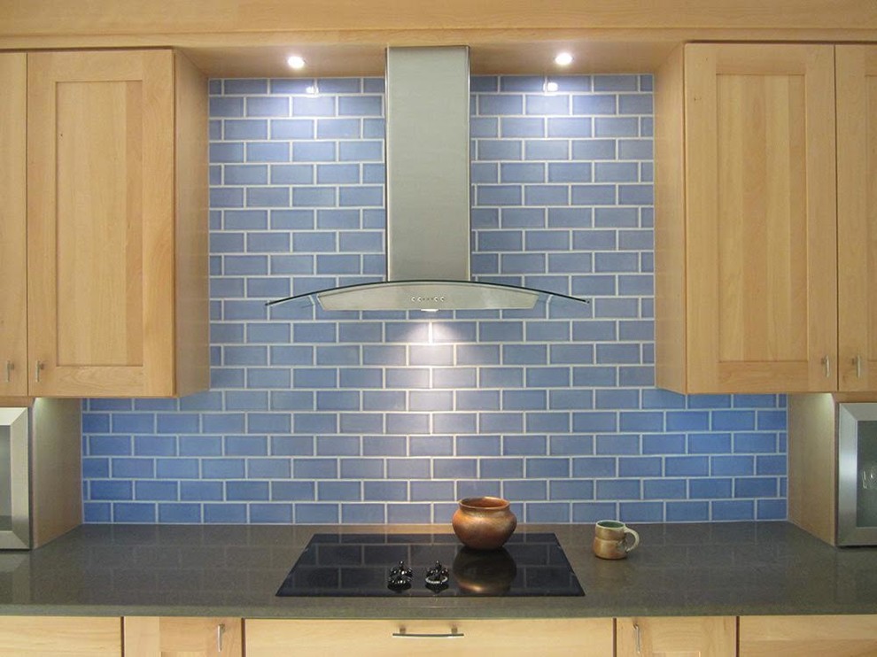 Kitchen - mid-sized transitional kitchen idea in Phoenix with a farmhouse sink, shaker cabinets, light wood cabinets, recycled glass countertops, blue backsplash, subway tile backsplash and black appliances