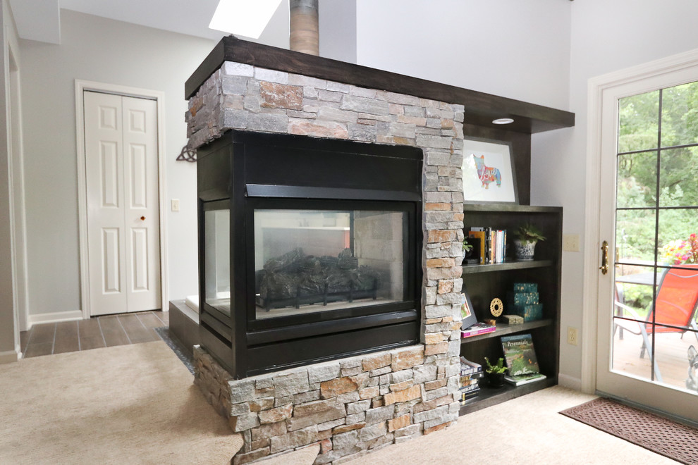 Example of a mid-sized transitional master carpeted and gray floor bedroom design with gray walls, a two-sided fireplace and a stone fireplace