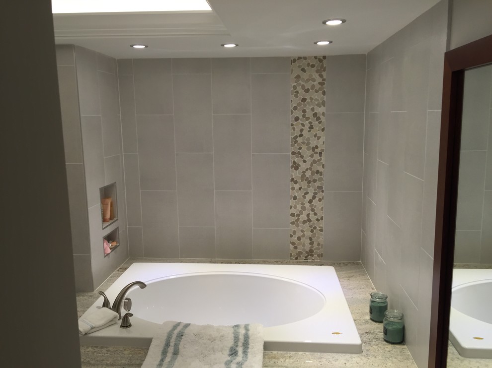 Drop-in bathtub - mid-sized transitional master gray tile and porcelain tile gray floor drop-in bathtub idea in Miami with shaker cabinets, dark wood cabinets, gray walls, an undermount sink and granite countertops