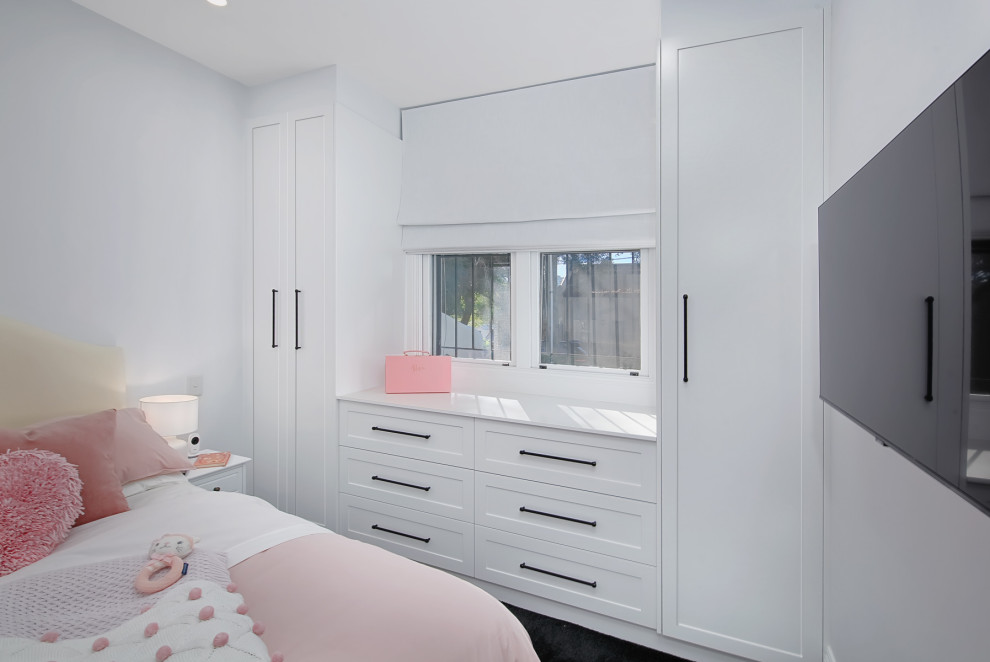 Exemple d'une petite armoire encastrée moderne neutre avec un placard à porte shaker, des portes de placard blanches, moquette et un sol noir.
