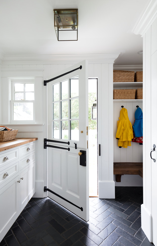 Traditional mudroom in New York with white walls, slate floors, a dutch front door, a white front door and black floor.