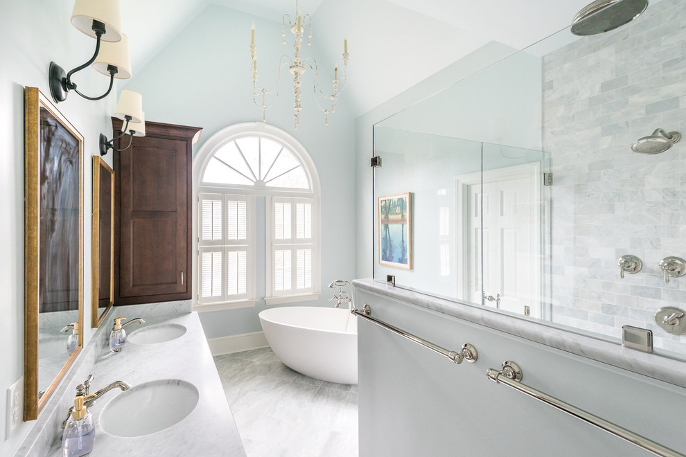 Inspiration for a master marble tile marble floor freestanding bathtub remodel in Richmond with beaded inset cabinets, blue walls, an undermount sink, marble countertops and a hinged shower door