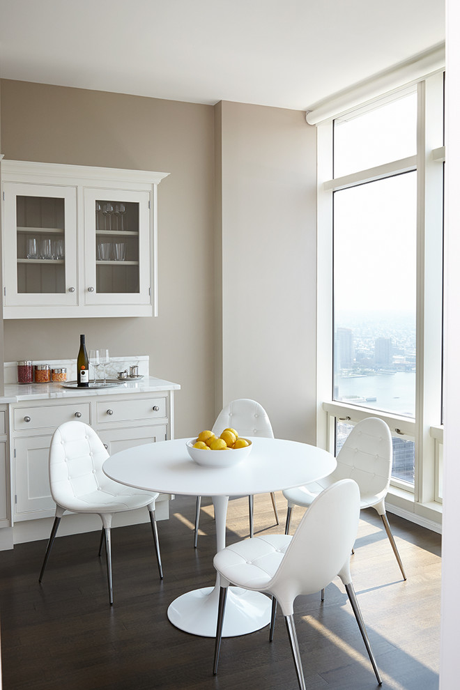 This is an example of a mid-sized modern eat-in kitchen in Other with shaker cabinets, white cabinets, marble benchtops, stainless steel appliances, dark hardwood floors, a peninsula, brown floor and white benchtop.