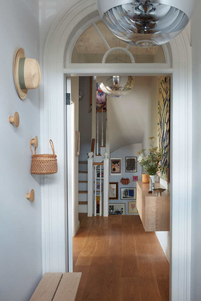 Inspiration for a mid-sized transitional hallway in Devon with grey walls, medium hardwood floors and brown floor.