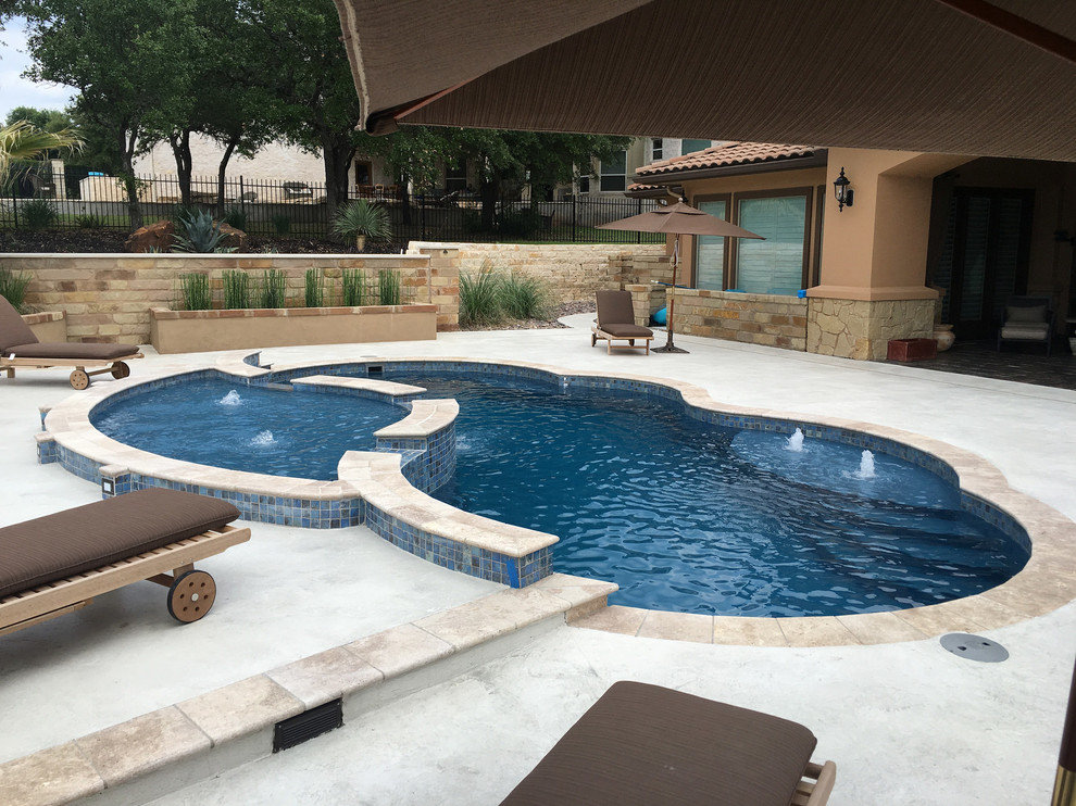 This is an example of a mid-sized modern backyard custom-shaped lap pool in Austin with a water feature and concrete slab.