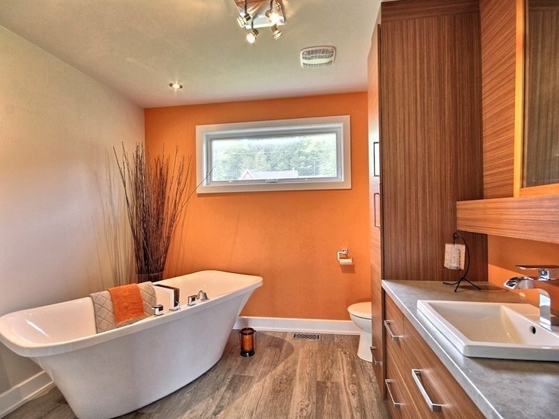 Design ideas for a mid-sized contemporary master bathroom in Ottawa with flat-panel cabinets, brown cabinets, brown tile, ceramic tile, orange walls and laminate benchtops.
