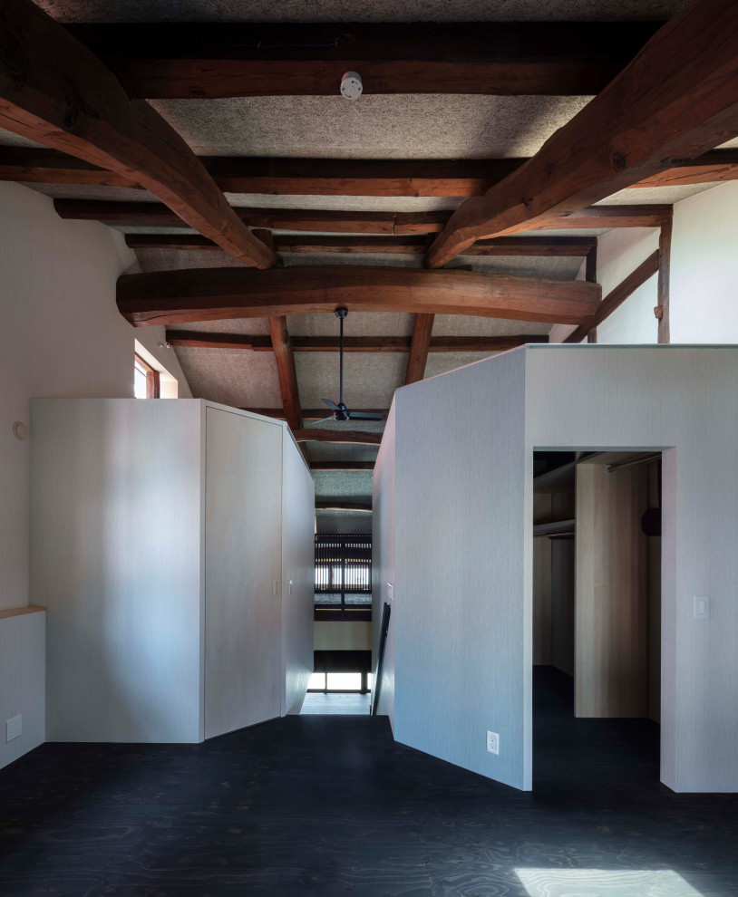 Стильный дизайн: хозяйская спальня среднего размера в восточном стиле с серыми стенами, полом из фанеры, черным полом, балками на потолке и обоями на стенах без камина - последний тренд