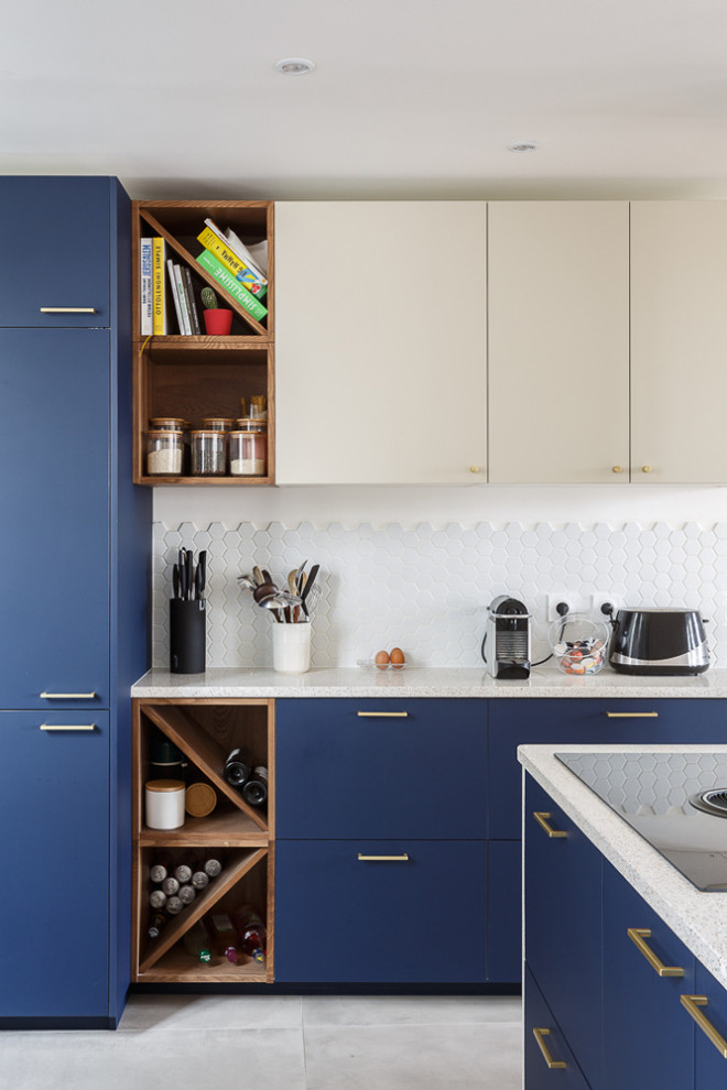 Mid-sized contemporary u-shaped open plan kitchen in Paris with an undermount sink, beaded inset cabinets, blue cabinets, terrazzo benchtops, white splashback, ceramic splashback, panelled appliances, ceramic floors, a peninsula, grey floor and white benchtop.