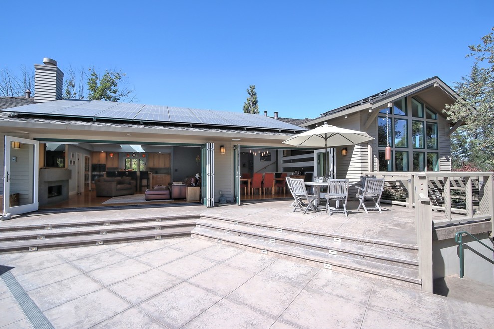 This is an example of a contemporary backyard patio in San Francisco with concrete pavers and a roof extension.
