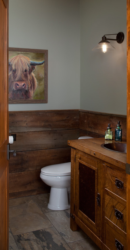 Inspiration for a small traditional bathroom in Grand Rapids with a drop-in sink, flat-panel cabinets, medium wood cabinets, wood benchtops, a one-piece toilet, multi-coloured tile, stone slab, blue walls and slate floors.