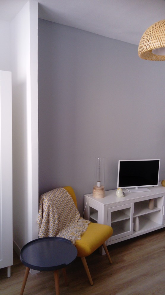 This is an example of a small scandinavian enclosed living room in Marseille with grey walls, laminate floors, no fireplace, a freestanding tv and beige floor.