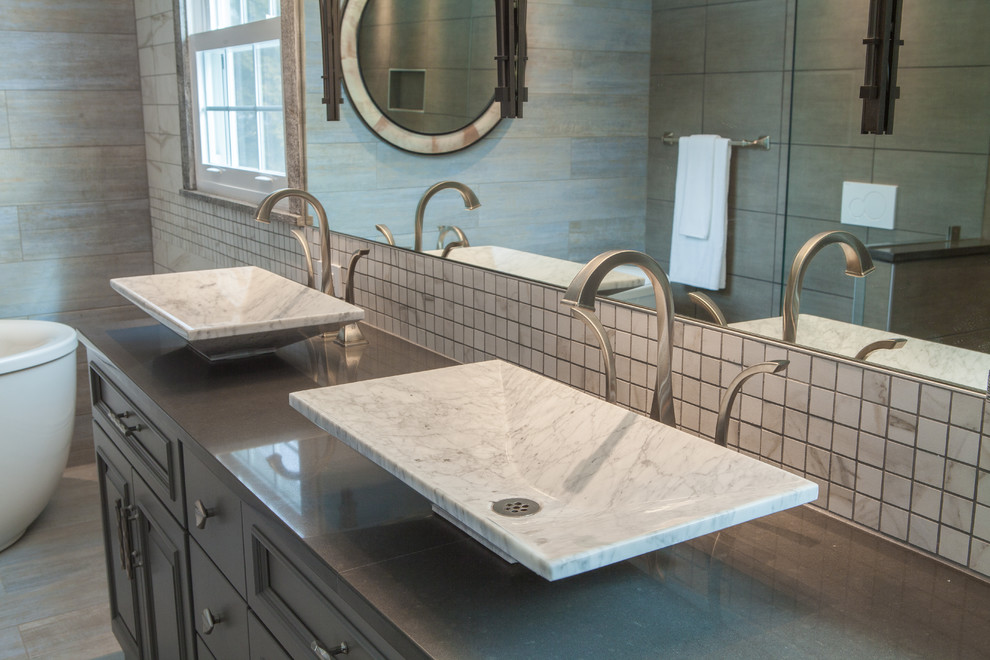 Inspiration for a large transitional master bathroom in Philadelphia with raised-panel cabinets, grey cabinets, a freestanding tub, a curbless shower, a wall-mount toilet, gray tile, multi-coloured walls, a vessel sink, engineered quartz benchtops, cement tiles and blue floor.