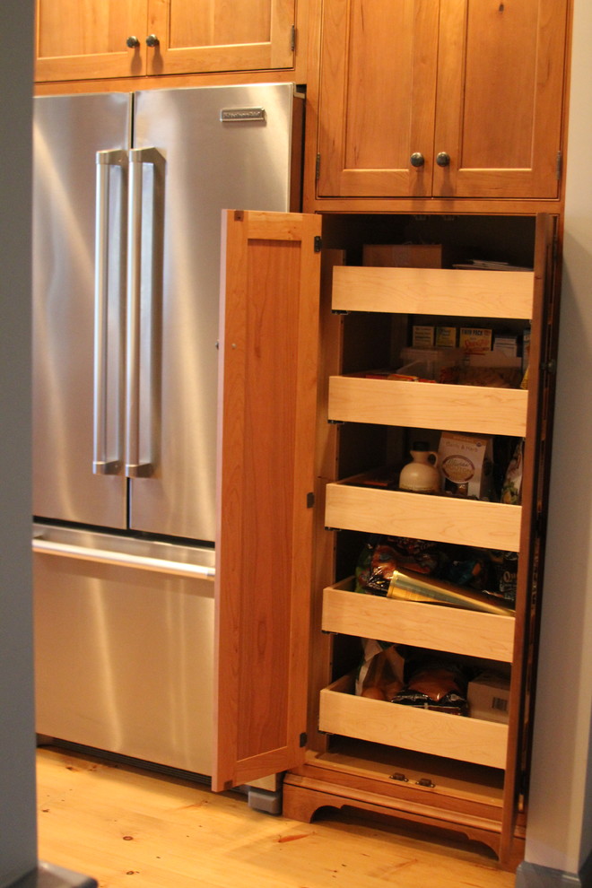 Inspiration for a large transitional galley eat-in kitchen remodel in Boston with raised-panel cabinets, medium tone wood cabinets, stainless steel appliances, marble countertops, a farmhouse sink and a peninsula