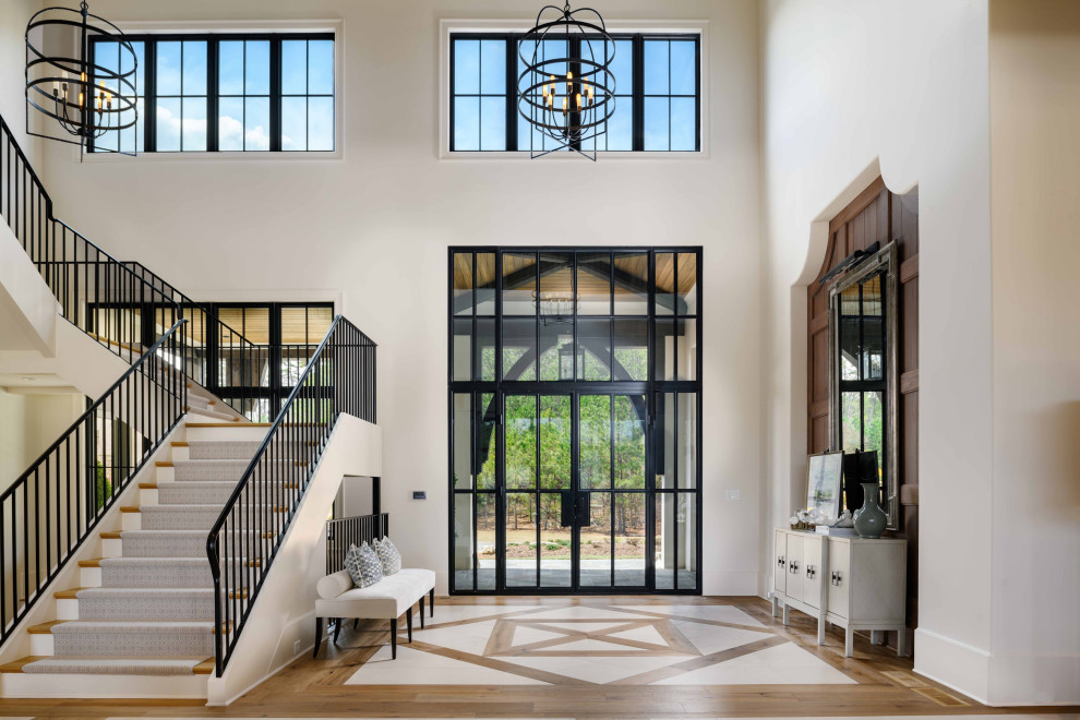 Expansive traditional foyer in Atlanta with light hardwood flooring, brown floors, white walls, a double front door, a black front door and panelled walls.