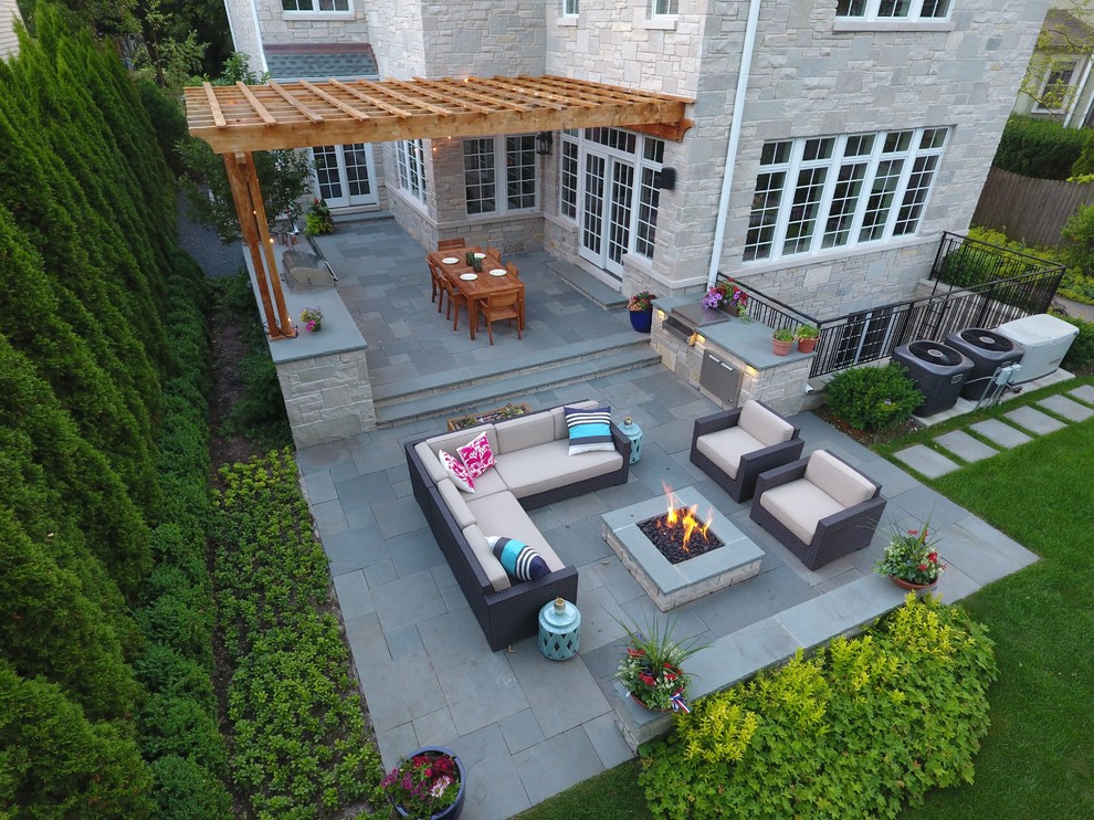 Inspiration for a large contemporary backyard partial sun garden in Chicago with a fire feature and natural stone pavers.