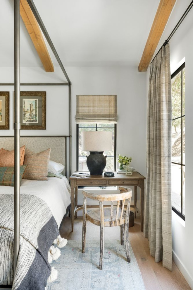 Diseño de dormitorio principal campestre de tamaño medio sin chimenea con paredes blancas y suelo de madera en tonos medios