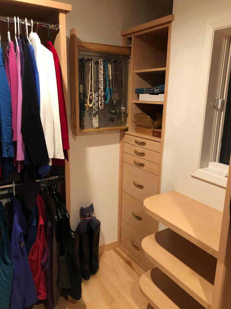 This is an example of a small contemporary gender neutral walk-in wardrobe in Other with light wood cabinets, light hardwood flooring and brown floors.