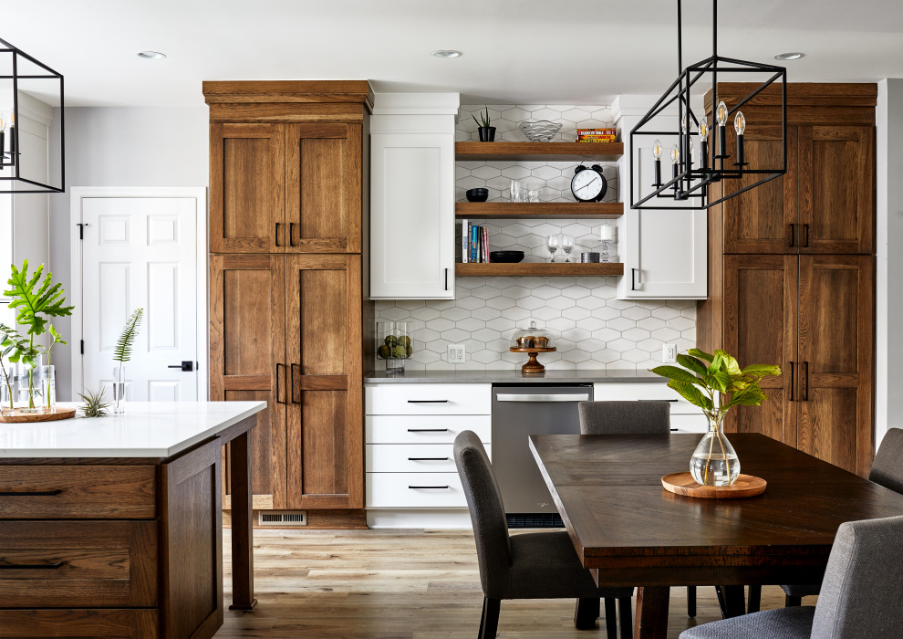 Large transitional u-shaped vinyl floor and brown floor eat-in kitchen photo in DC Metro with a farmhouse sink, shaker cabinets, quartz countertops, white backsplash, ceramic backsplash, stainless steel appliances, an island and white countertops