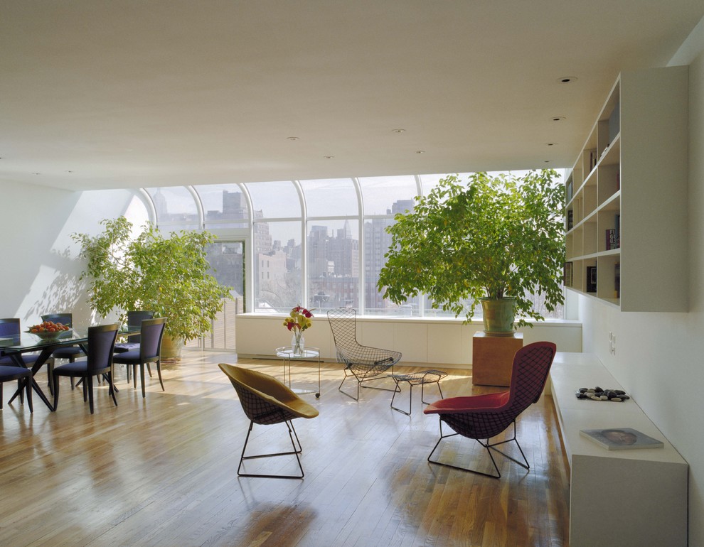 Photo of a large modern open concept living room in New York with white walls, light hardwood floors and no fireplace.
