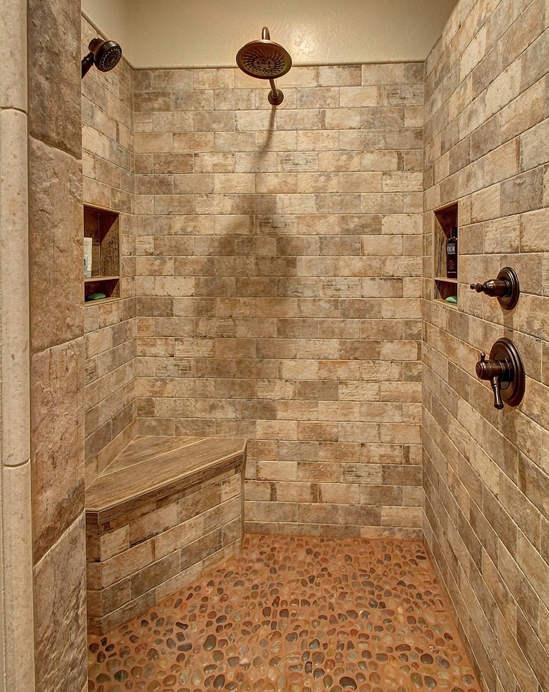 Example of a mid-sized mountain style master stone tile pebble tile floor walk-in shower design in Phoenix with beige walls