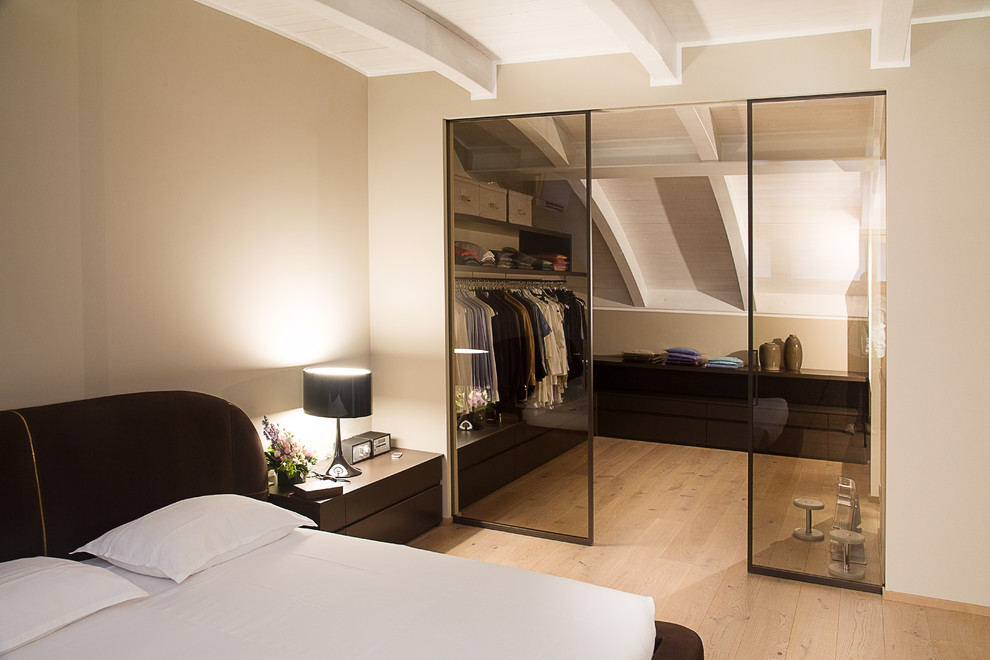 This is an example of a contemporary men's walk-in wardrobe in Venice with light hardwood floors.