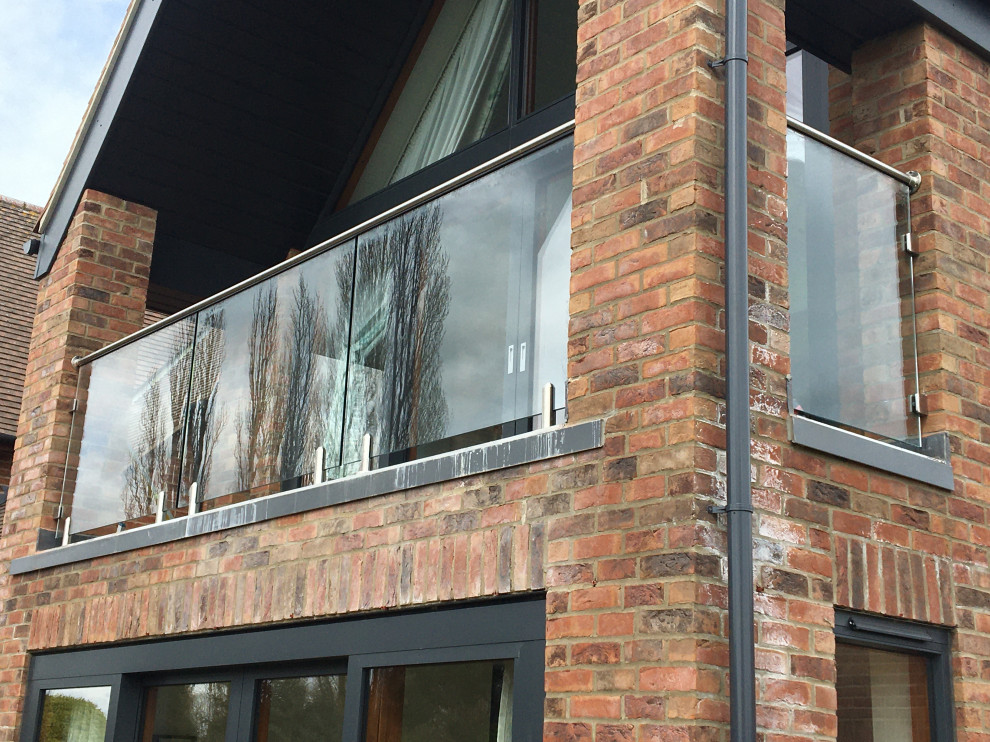 Esempio di un grande privacy sul balcone minimalista con un tetto a sbalzo e parapetto in vetro
