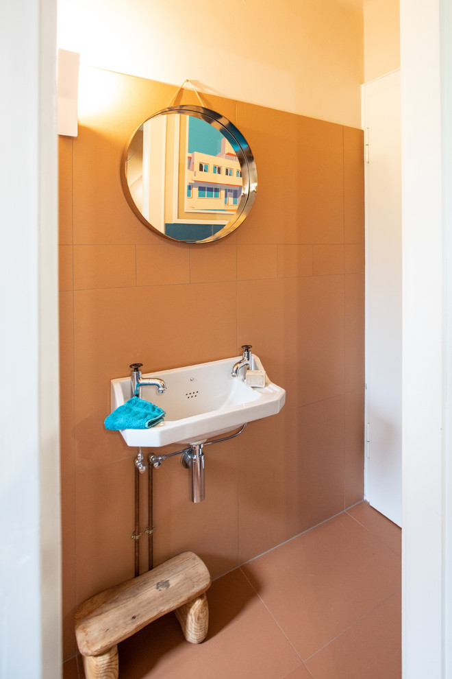 Inspiration for a mid-sized midcentury master bathroom in Strasbourg with orange tile, orange floor, cement tile, orange walls, beaded inset cabinets, blue cabinets, a curbless shower, a two-piece toilet, cement tiles, a vessel sink, laminate benchtops, an open shower and blue benchtops.