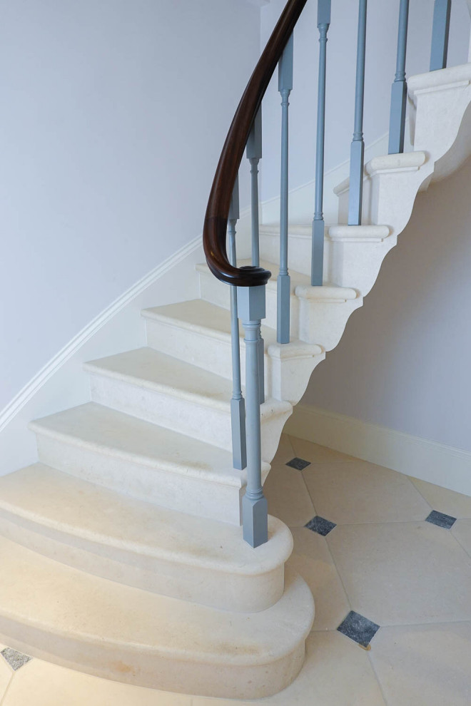 Inspiration for a traditional curved wood railing staircase in Other with limestone treads and limestone risers.