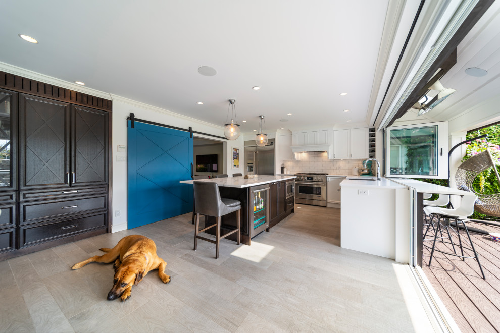 Inspiration for a transitional beige floor kitchen remodel in Vancouver with white backsplash, stainless steel appliances, an island and white countertops