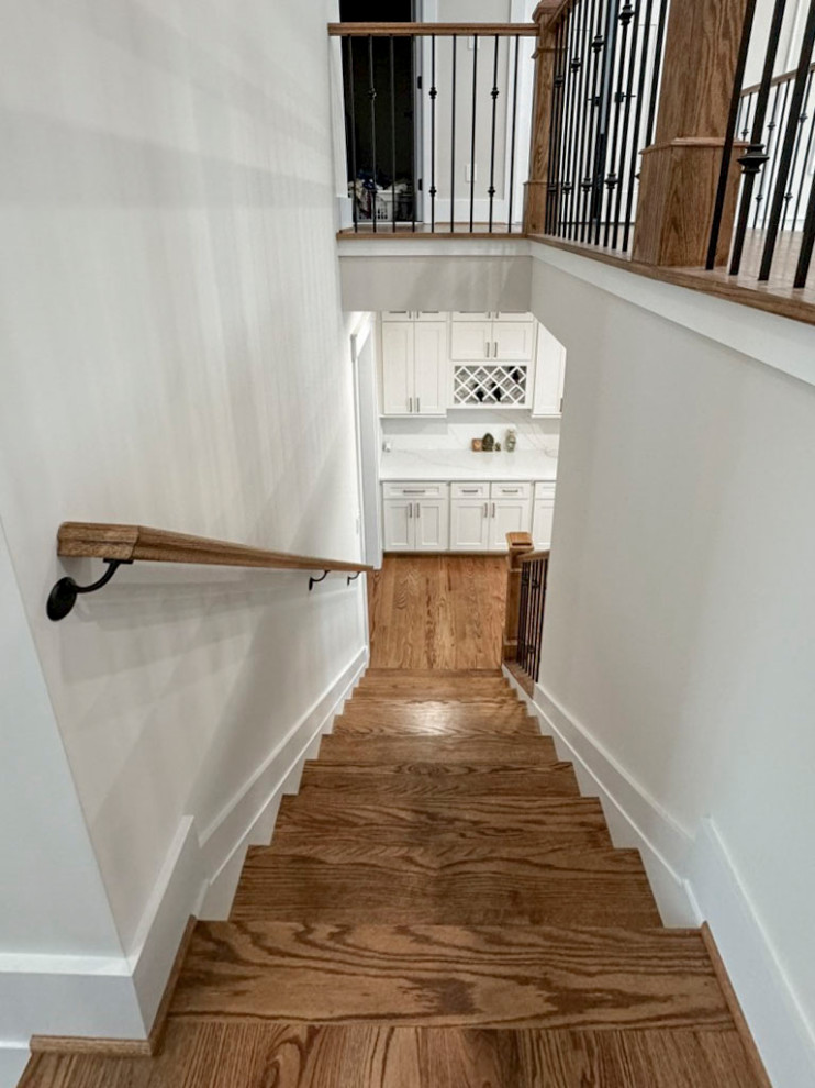 Cette photo montre un escalier courbe chic de taille moyenne avec des marches en bois, des contremarches en bois et un garde-corps en matériaux mixtes.