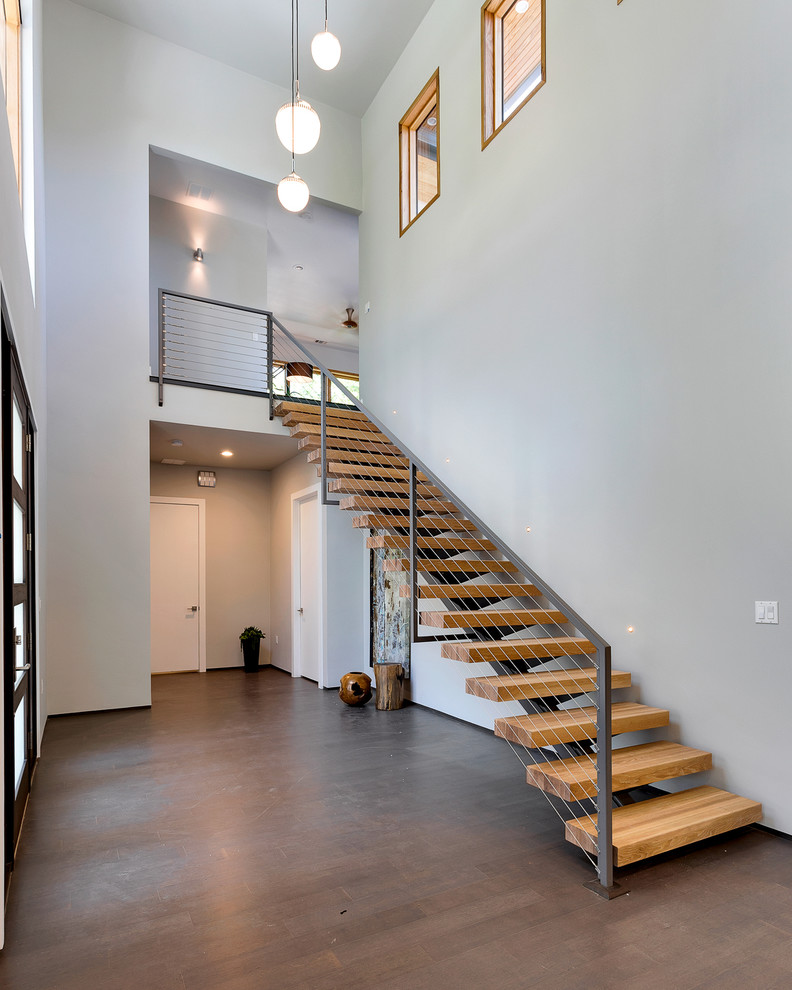 This is an example of a large contemporary foyer in Austin with grey walls, bamboo floors, a single front door and a black front door.