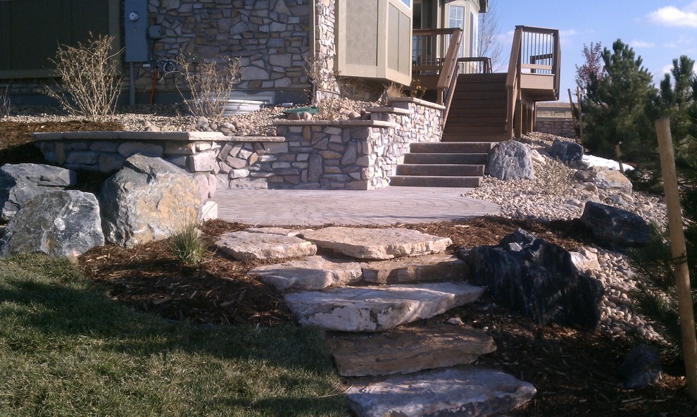 Design ideas for a mid-sized country backyard full sun garden in Denver with a retaining wall and concrete pavers.