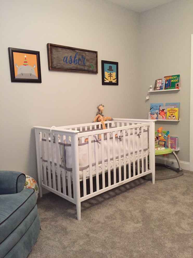 Photo of a medium sized contemporary nursery for boys with beige walls, carpet and beige floors.