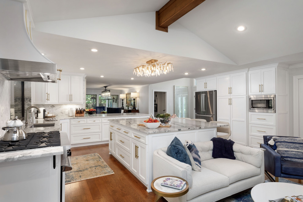 Transitional u-shaped medium tone wood floor and brown floor open concept kitchen photo in Dallas with an undermount sink, shaker cabinets, white cabinets, stainless steel appliances, an island and gray countertops