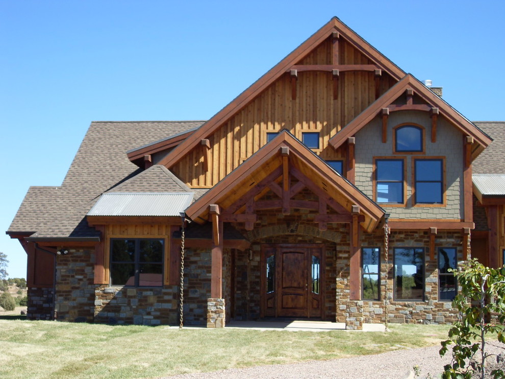 Large country two-storey multi-coloured house exterior in Phoenix with mixed siding, a hip roof and a shingle roof.