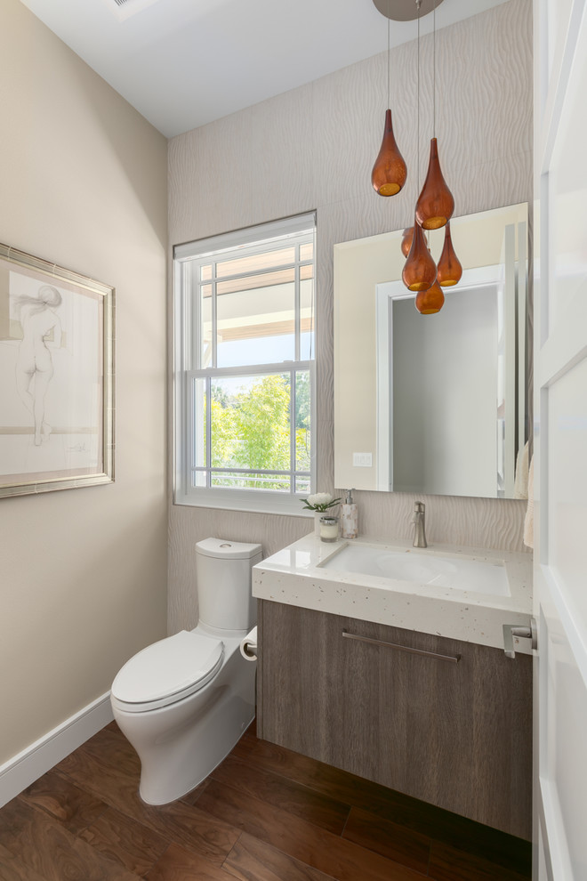 Inspiration for a small contemporary powder room in Tampa with flat-panel cabinets, medium wood cabinets, a two-piece toilet, beige tile, porcelain tile, beige walls, medium hardwood floors, an undermount sink, engineered quartz benchtops and brown floor.