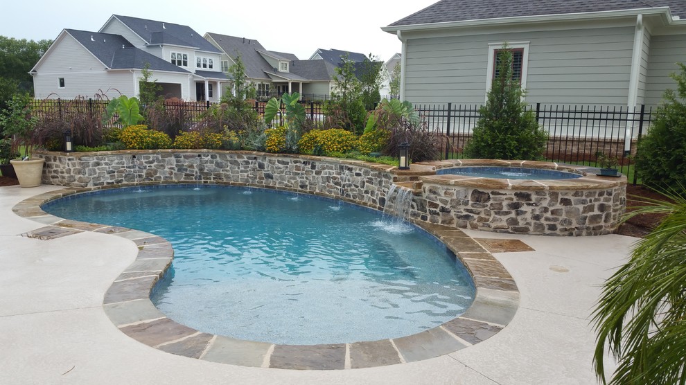 Mid-sized transitional backyard kidney-shaped natural pool in Atlanta with a hot tub and tile.