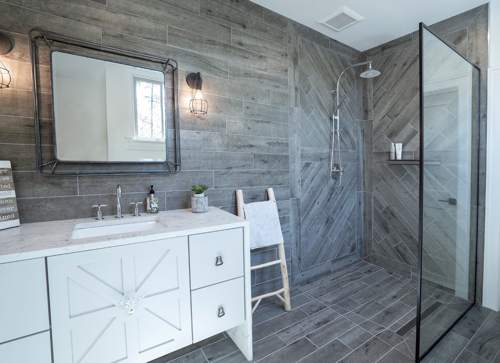 Mid-sized country kids bathroom in Atlanta with grey cabinets, a curbless shower, a one-piece toilet, gray tile, porcelain tile, white walls, porcelain floors, an undermount sink, engineered quartz benchtops, grey floor, an open shower, white benchtops and recessed-panel cabinets.