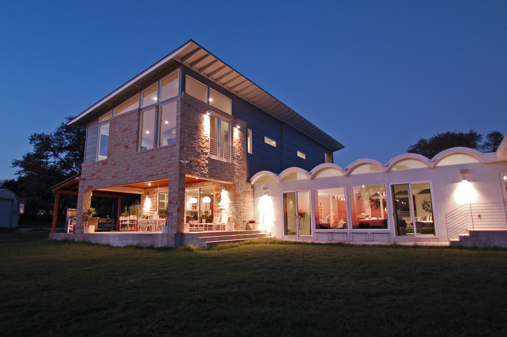 Design ideas for a contemporary two-storey exterior in Austin with stone veneer.