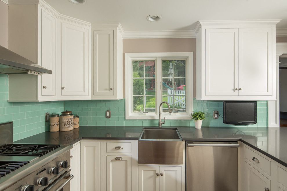 Inspiration for a mid-sized traditional u-shaped separate kitchen in New York with a farmhouse sink, recessed-panel cabinets, white cabinets, stainless steel benchtops, green splashback, subway tile splashback, stainless steel appliances and a peninsula.