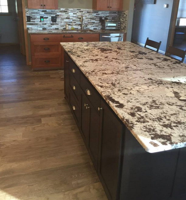 Kitchen - transitional kitchen idea in Minneapolis with flat-panel cabinets, dark wood cabinets, stainless steel appliances and an island