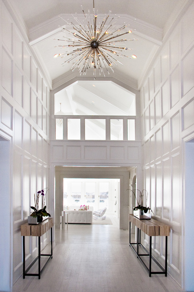 This is an example of a large beach style foyer in New York with white walls.