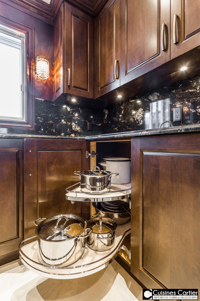 Design ideas for an expansive traditional u-shaped open plan kitchen in Montreal with an undermount sink, raised-panel cabinets, dark wood cabinets, black splashback, stone slab splashback, stainless steel appliances, ceramic floors and with island.