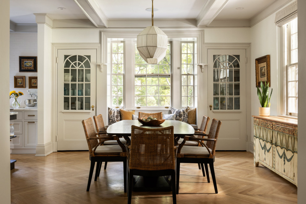 Example of a large classic medium tone wood floor and coffered ceiling kitchen/dining room combo design in New York with white walls